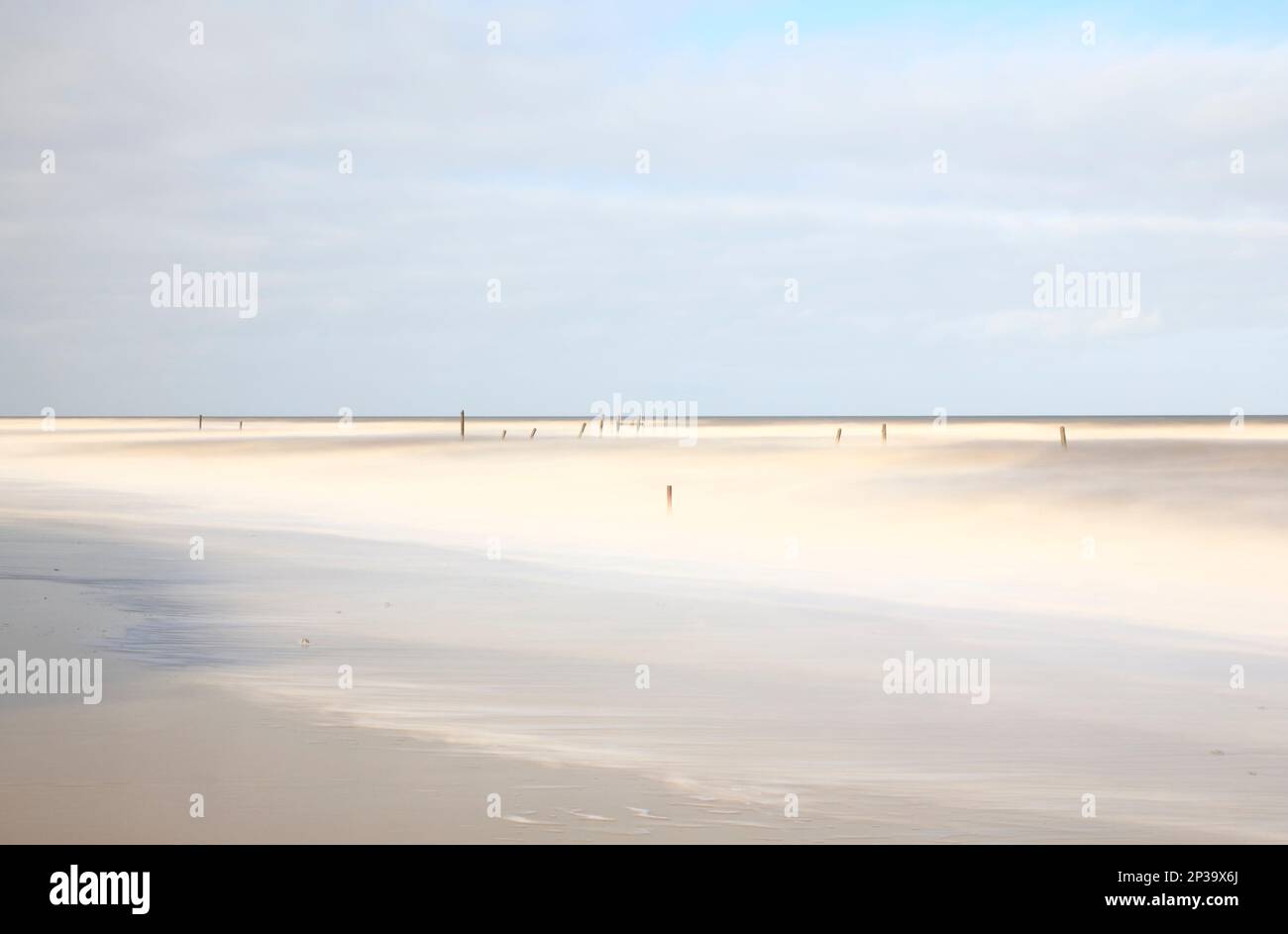 Eine lange Exposition an der Küste mit verlassenen Wellenbrechern im Meer an der Norfolkküste in Happisburgh, Norfolk, England, Großbritannien. Stockfoto