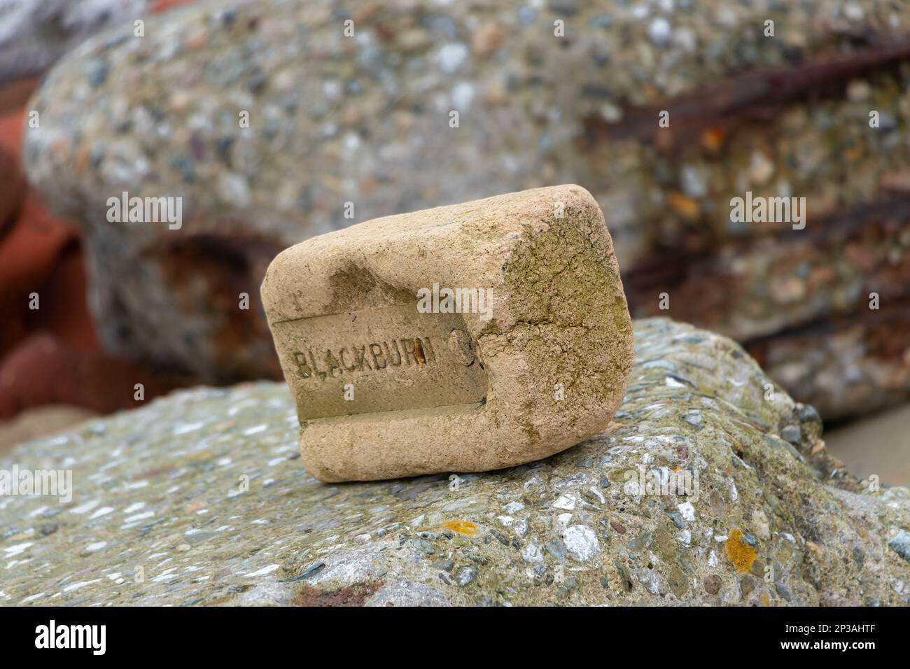 Abgeschiedene alte Backsteine am crosby Beach mit dem Wort Blackburn Stockfoto