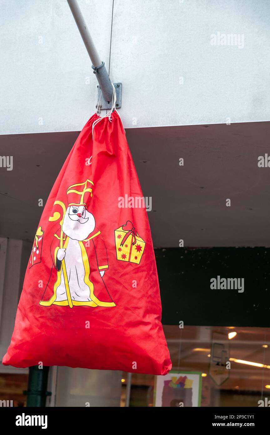 Große rote Tasche mit Sinterklaas Dutch Kinderparty, die an einem Fahnenmast hängt Stockfoto