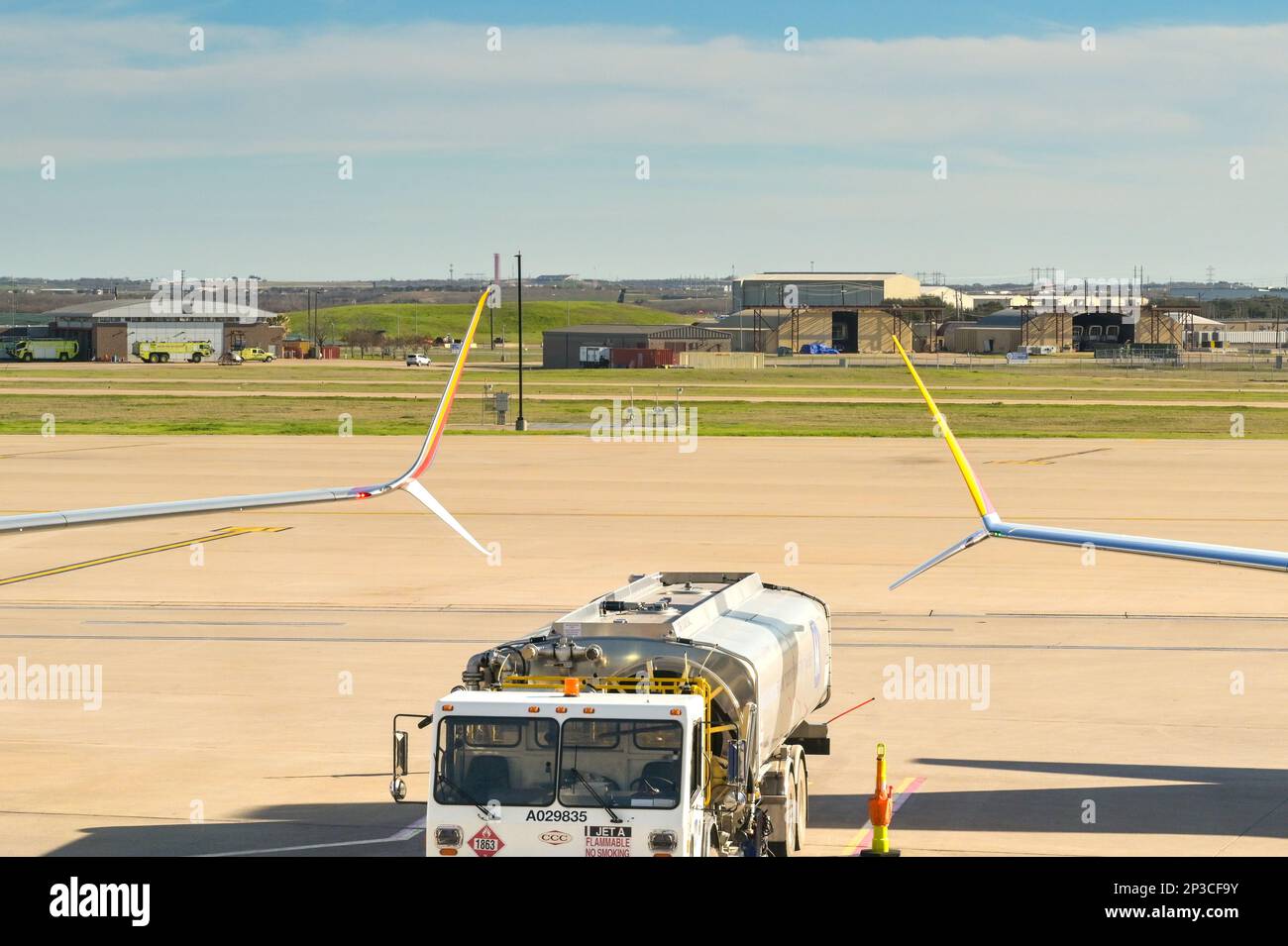 Austin, Texas - Februar 2023: Delta Aircraft Tanken Tankwagen parkt zwischen den Flügelspitzen zweier Flugzeuge am Stadtflughafen Stockfoto