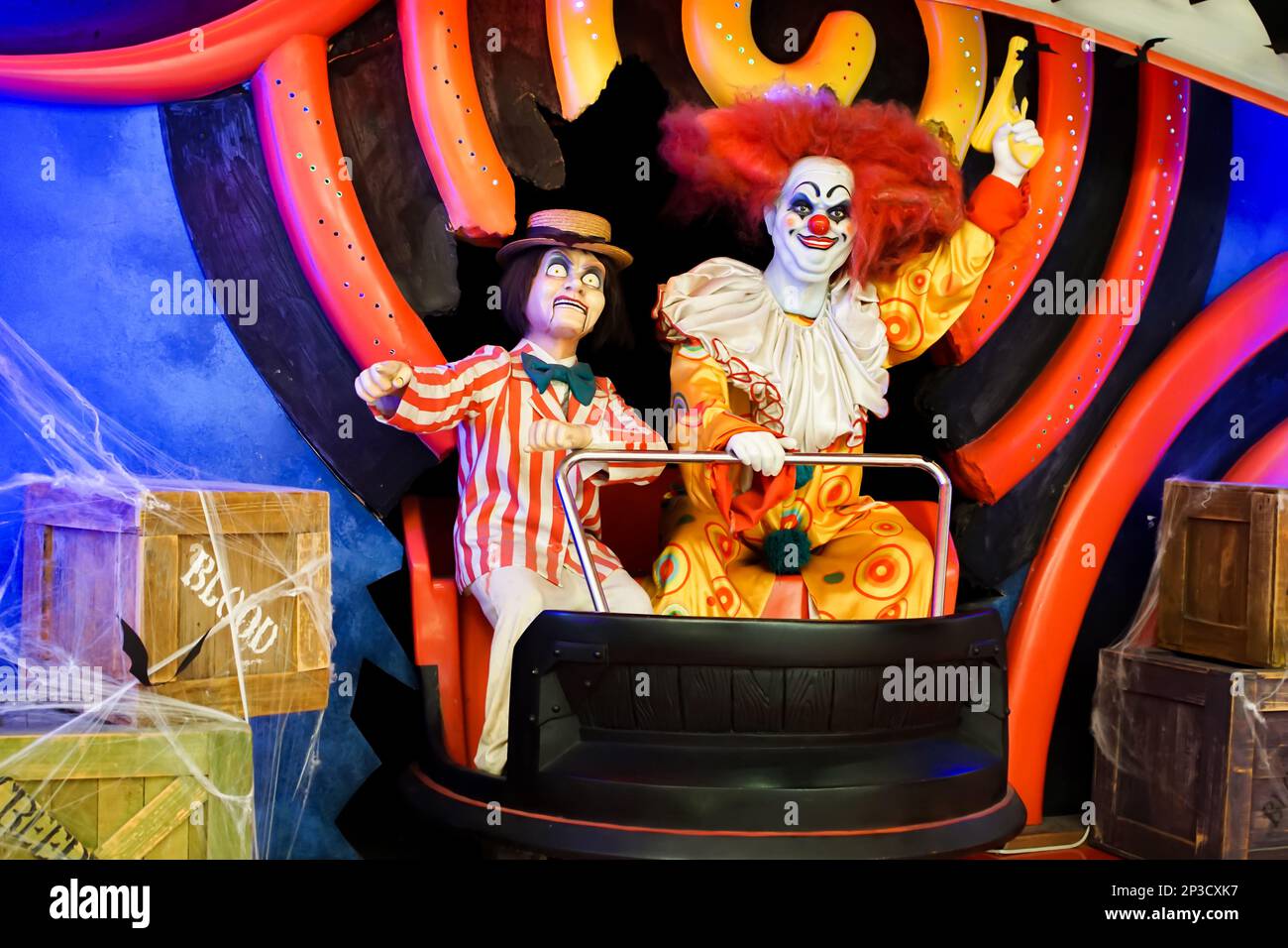Zwei lächelnde Clown-Puppen, die mit einer Waffe in der Hand in die Kamera schauen. Hochwertiges Foto Stockfoto