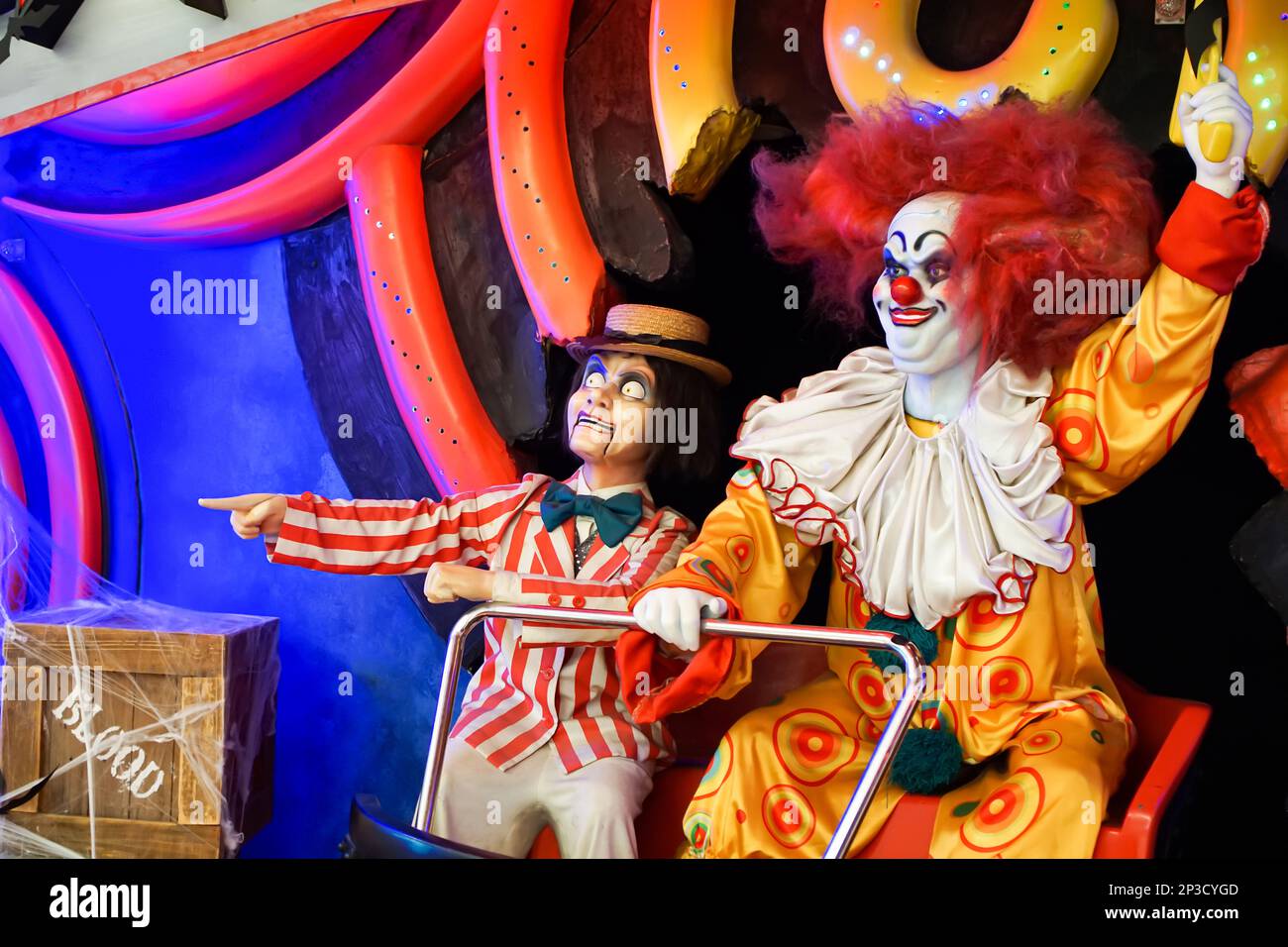Die Puppen-Clowns sitzen auf einem Trolley und schwenken mit den Armen in die Richtung. Beängstigend. Halloween. Die Jagd. Hochwertiges Foto Stockfoto