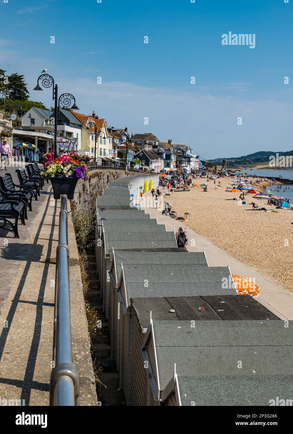 Eine Reihe Strandhütten auf der Marine Parade am Kieselstrand, Lyme Regis in Summer, Dorset, England, Großbritannien Stockfoto