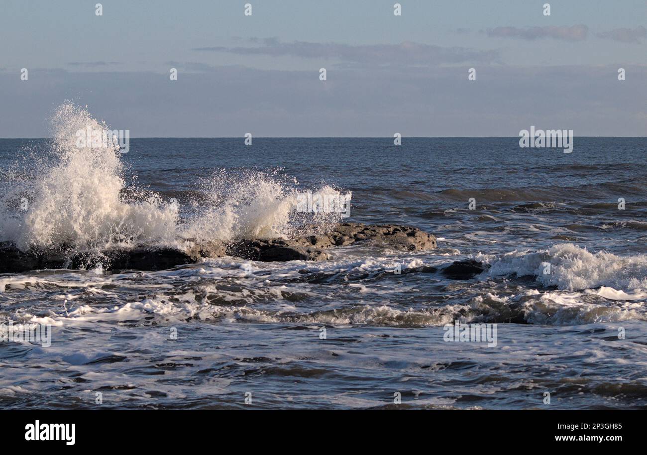 Wellen stürzen auf Felsen in Saltwick Bay bei Whitby, North Yorkshire Stockfoto