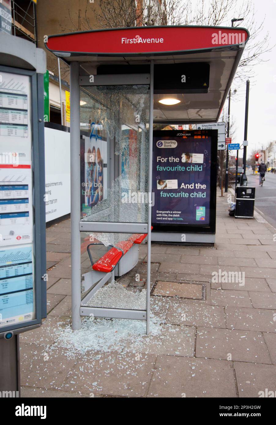 Ein verwundeter Busbunker in Acton Town London. Zerbrochenes Glas liegt auf dem Bürgersteig, als zwei Glasscheiben zertrümmert wurden. Stockfoto
