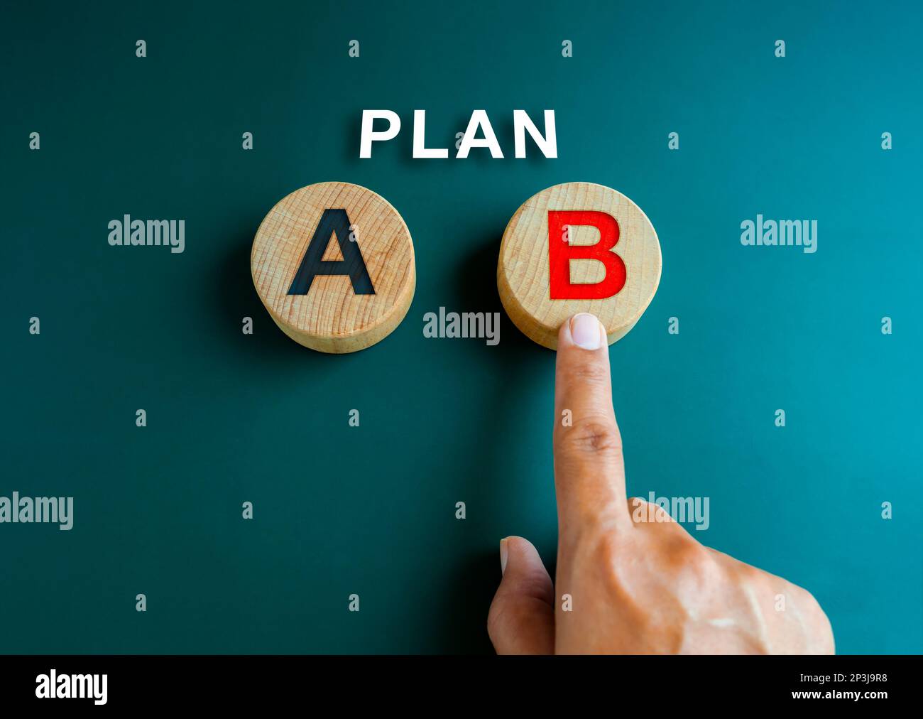 Plan B, Geschäftsstrategie und Entscheidungskonzept. Plan, der Text über der Hand, der auswählt, mit dem Finger auf Plan B zeigt, rotes Alphabet auf einem runden Holzblock Stockfoto