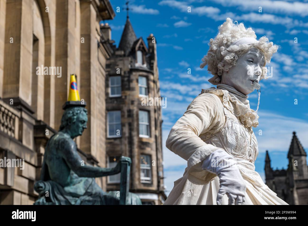 Lebendige Statue Street Performer Woman dressed in white by David Hume Statue, Royal Mile, Edinburgh, Schottland, UK Stockfoto