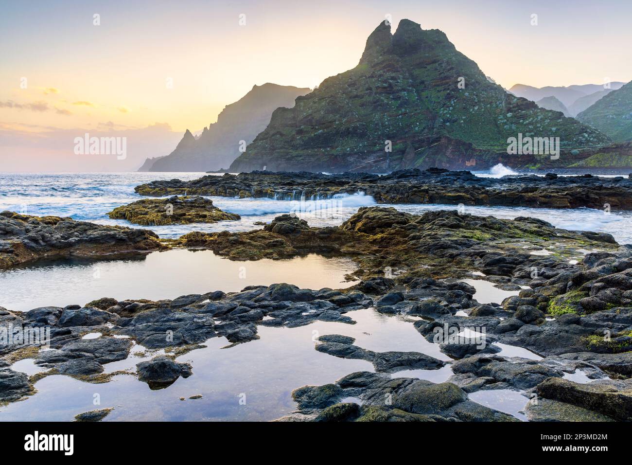 Die zerklüftete Küste von Punta del Hidalgo bei Sonnenaufgang. Mit den Anaga-Bergen im Hintergrund, Teneriffa, Kanarische Inseln Stockfoto