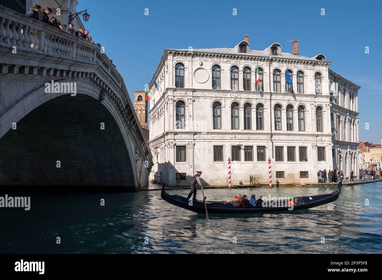 Gondoliere, der seinen Handel auf dem Canal Grande an der Rialto-Brücke, Venedig, Italien, betreibt Stockfoto