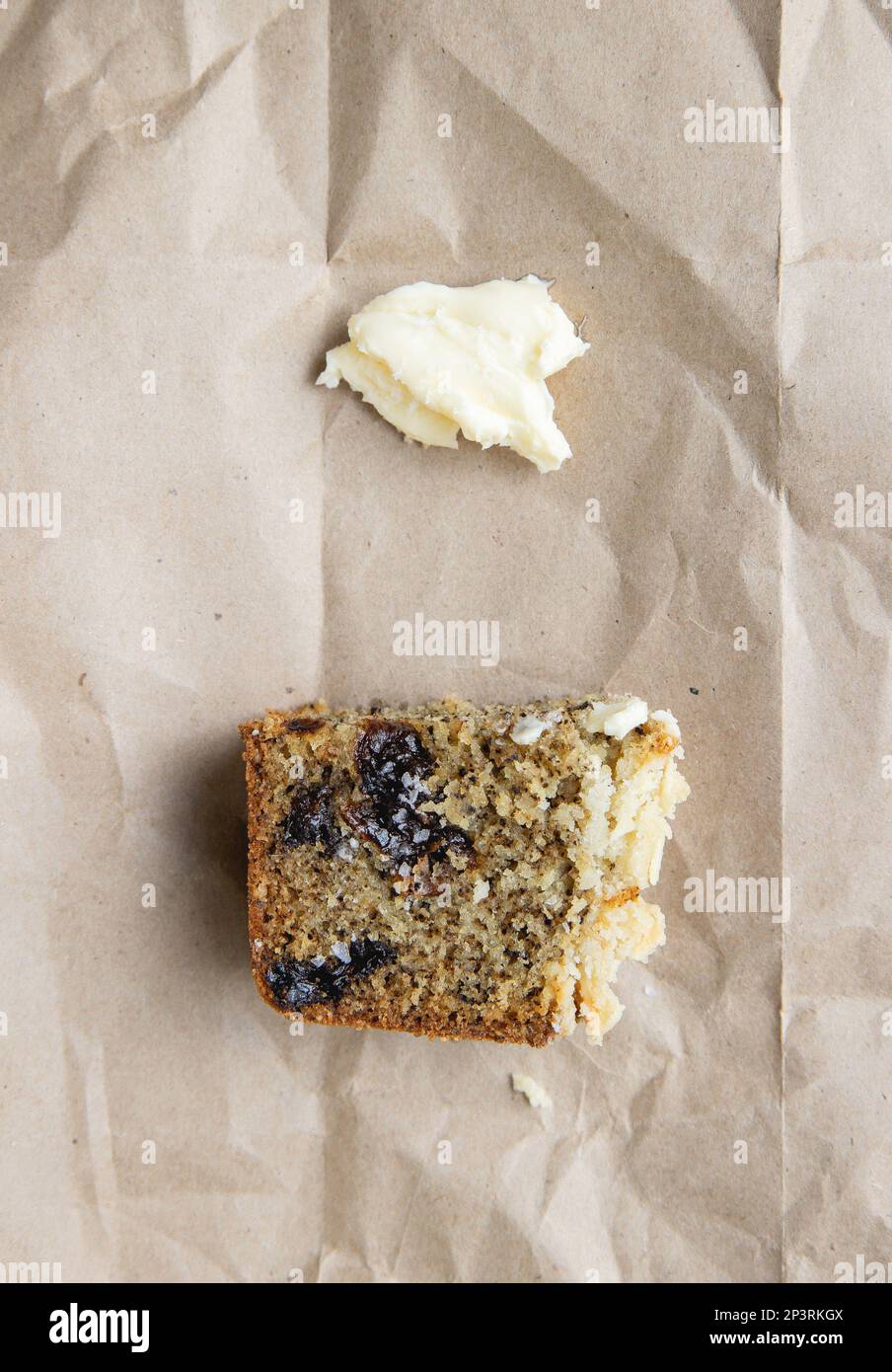 Ein Stück Kuchen mit Butter auf braunem Papier Stockfoto