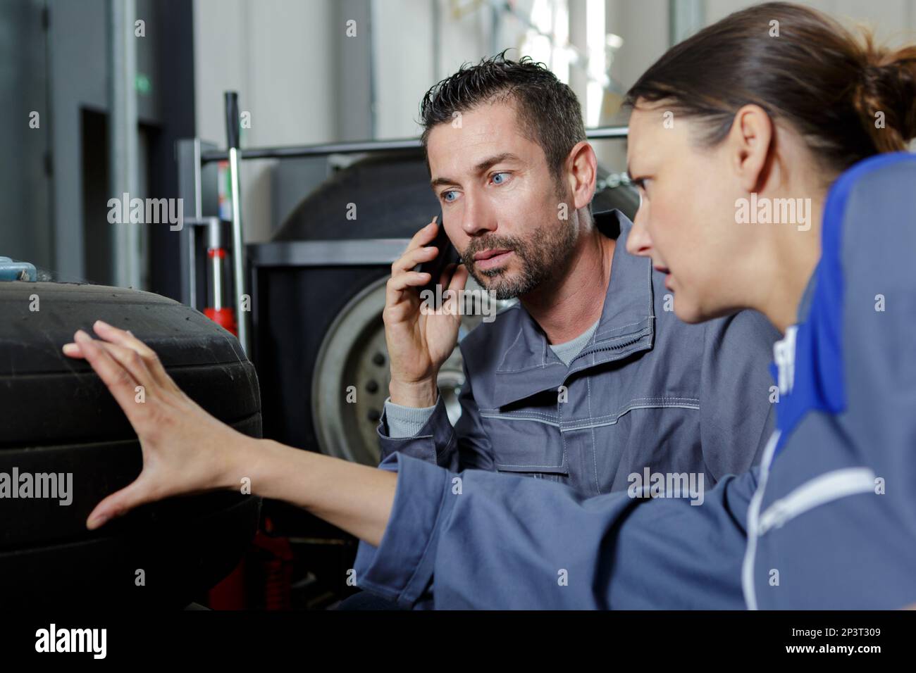 Mechaniker und Mechaniker prüfen Reifen Stockfoto