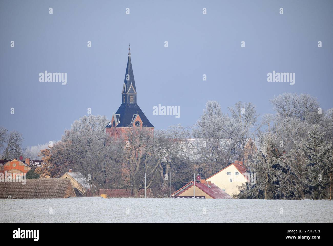 Fehrbellin, Deutschland. 15. Dezember 2022. Kirche und Häuser von Hakenberg. In der Nähe des Eingangs zum Dorf steht das Denkmal zur Erinnerung an die Schlacht von Fehrbellin (18. Juni 1675). Kredit: Soeren Stache/dpa/Alamy Live News Stockfoto