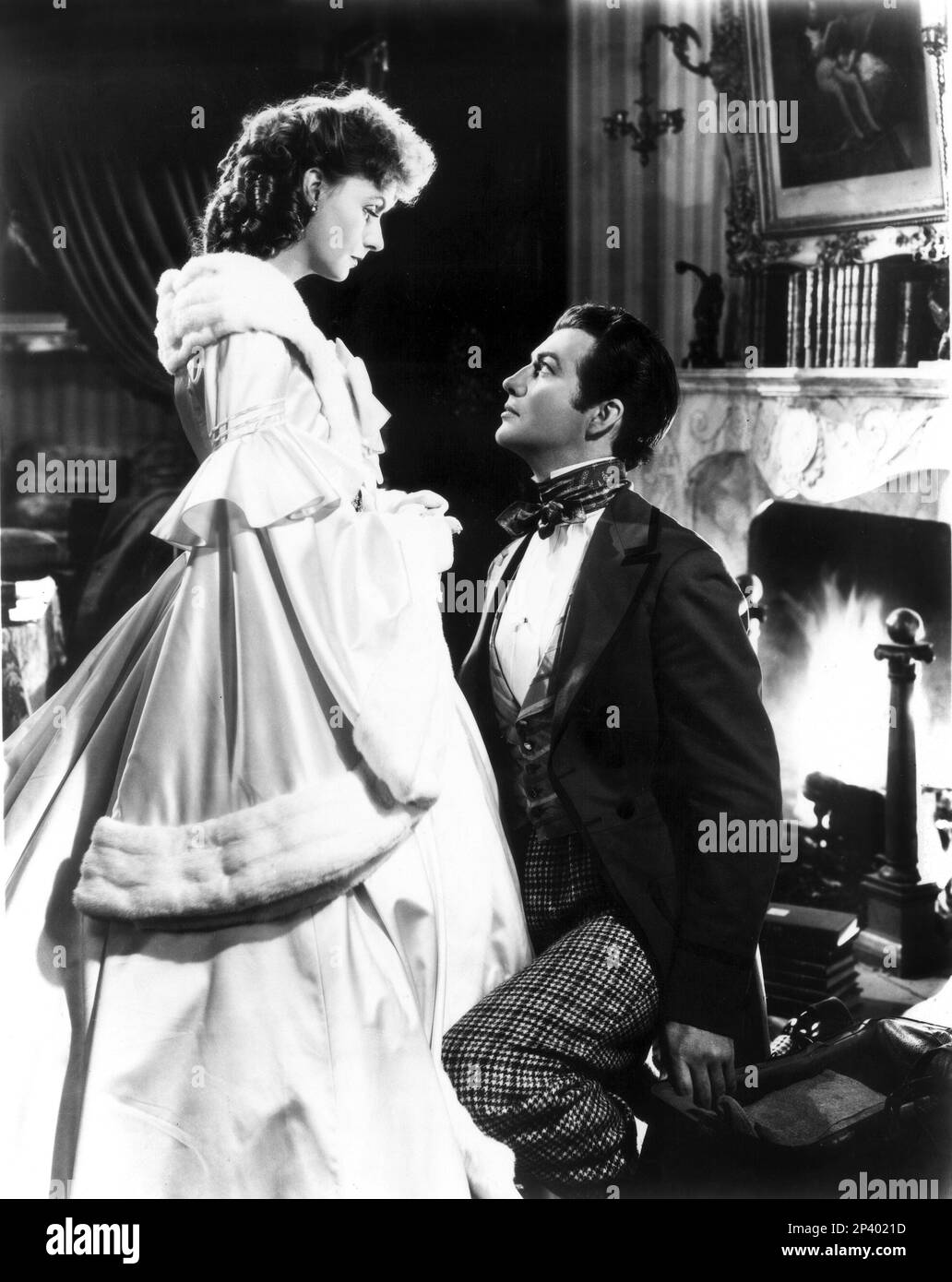 1937 : die Filmschauspielerin GRETA GARBO und ROBERT TAYLOR in CAMILLE ( Margherita Gauthier ) von George CUKOR , Von der Romantik von Alexandre DUMAS Fils - MGM-Publicity still - METRO GOLDWYN MAYER - FILM - KINO - PORTRAIT - boccoli - Locken - riccioli - profilo - Profil - papillon Krawatte - Cravatta - Innamorati - Liebhaber - amanti - SIGNORA DELLE CAMELIE - caminetto - Rraso bianco - weißer Satin - Minenfell - Pelliccia ermellino --- Archivio GBB Stockfoto