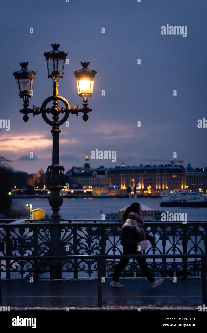 Eine Frau, die nachts allein auf der Djurgårdsbron in Stockholm, Schweden, spaziert Stockfoto