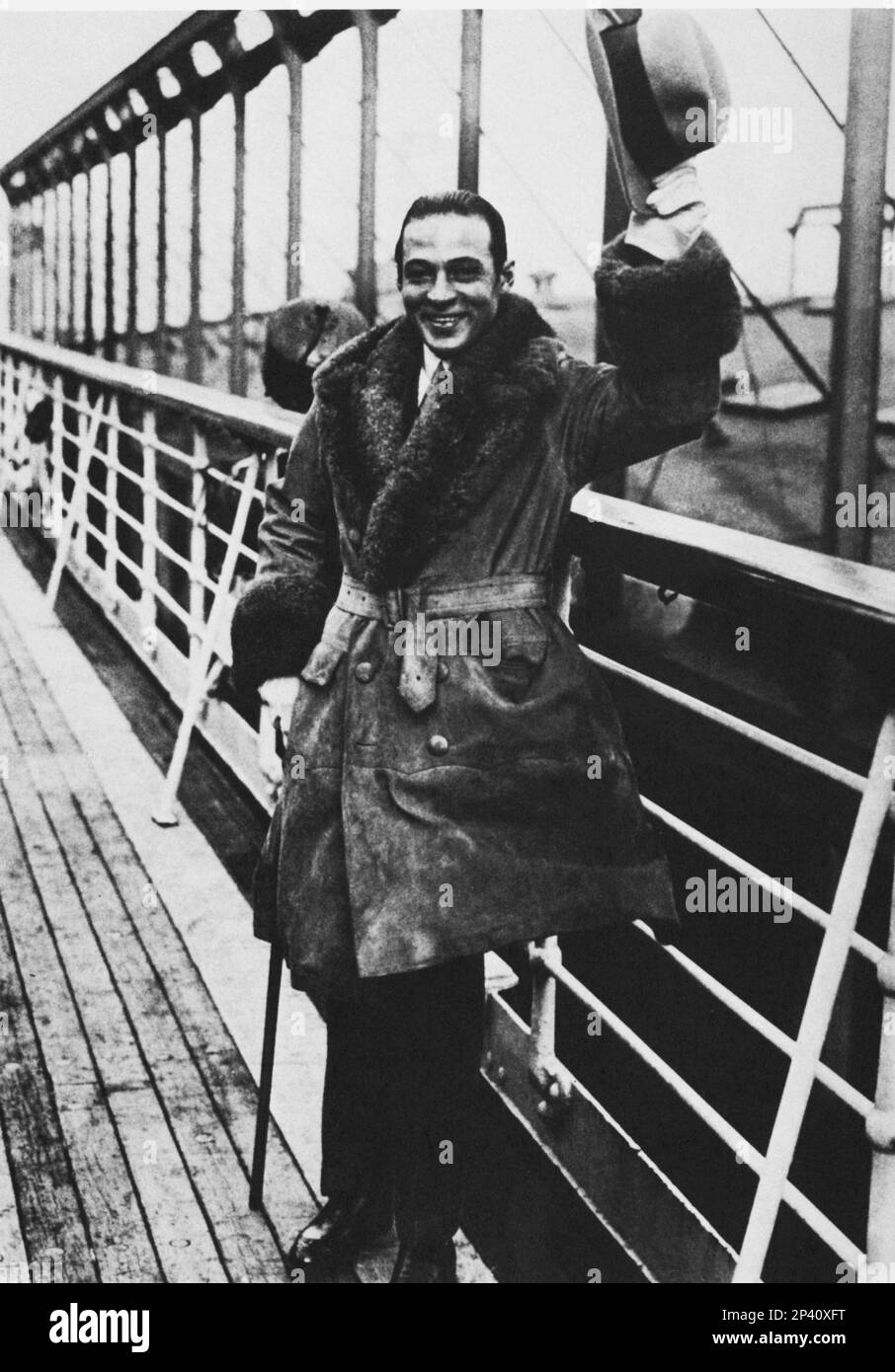 1925 , New York , USA : der Stummfilmdarsteller RUDOLPH VALENTINO ( geb. Rodolfo Guglielmi , 1895 - 1926 ) fährt nach Paris , Frankreich , Nach seiner Trennung von ihrer Frau Natasha Rambova - CINEMA MUTO - attore cinematografico - LATEINISCHER LIEBHABER - italoamericano - italo americano - italo-americano - emigrante - italo-american - Portrait - ritratto - hat - cappello - ANNI VENTI - 20s - '20 - smile - sorriso - Nave - Boot - transatlantisch - transatlantico - Reise - Viaggio - Cappotto - Mantel - Pelliccia - Pelliccia - Pelz - Brilantina - Fett - Bastone da passeggio - Stock - Gürtel - Cintura Stockfoto