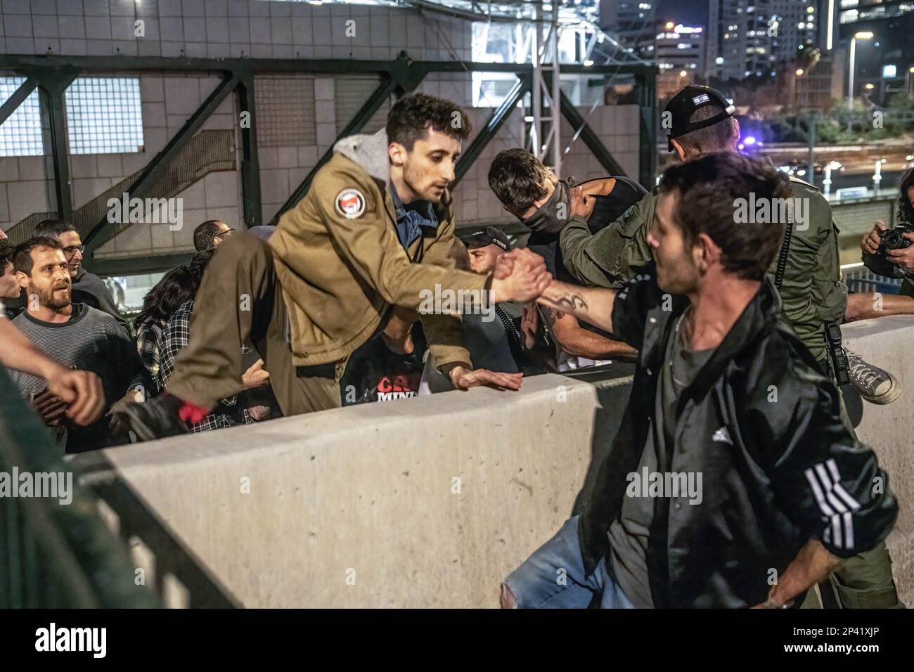 Tel Aviv, Israel. 04. März 2023. Demonstranten helfen sich gegenseitig, eine Barriere zu überwinden, um die Autobahn von Ayalon während der Demonstration zu blockieren. Mehr als 200.000 Menschen protestierten in Tel Aviv gegen Netanjahus rechtsextreme Regierung und ihre umstrittene Rechtsreform. Kredit: SOPA Images Limited/Alamy Live News Stockfoto