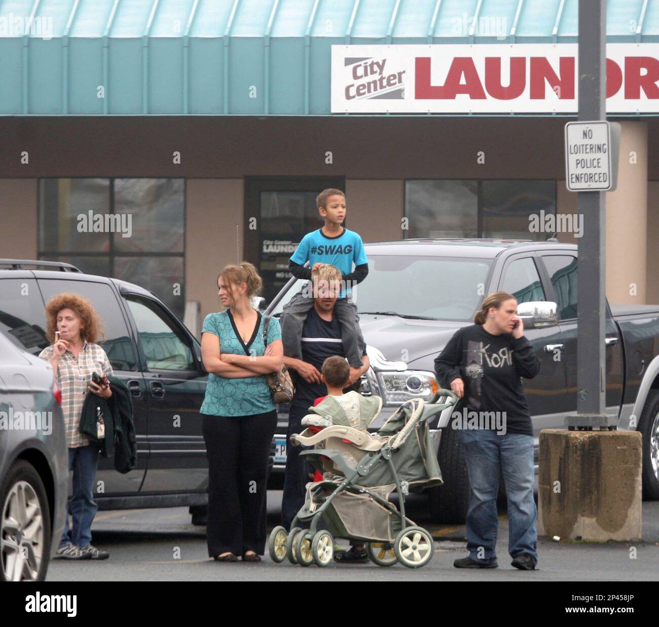 Bystanders watch as law enforcement surround the Landmark Apartments in downtown Stewartville, Minn., Thursday, Oct. 2, 2014, during an hours-long standoff involving a domestic altercation and a probation violation. A Rochester man with a lengthy criminal record was taken into custody by members of the Olmsted County Sheriff Department and Rochester-Olmsted County Emergency Response Unit and crisis negotiating team. (AP Photo/Rochester Post-Bulletin, Elizabeth Nida Obert) Stockfoto