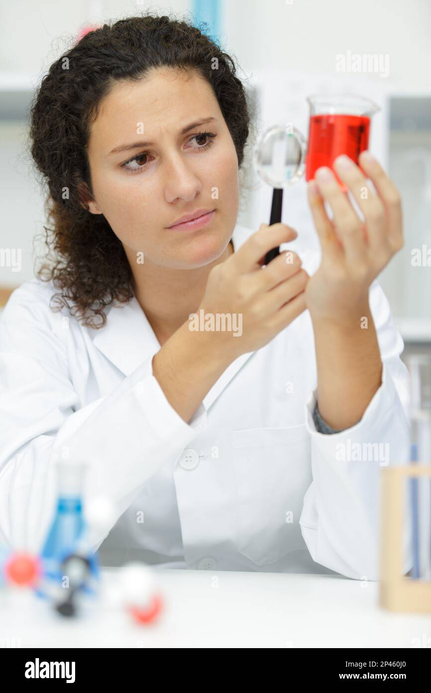 Frau, die im Labor eine Lupe benutzt Stockfoto