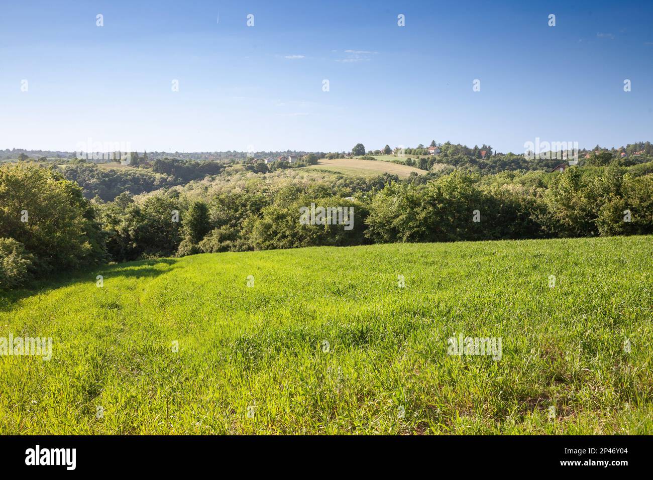 Bild einer typischen Landschaft Serbiens mit serbischen Höfen, einem seosko domacinstvo, umgeben von Feldern, in einem Tal von Barajevo. Stockfoto