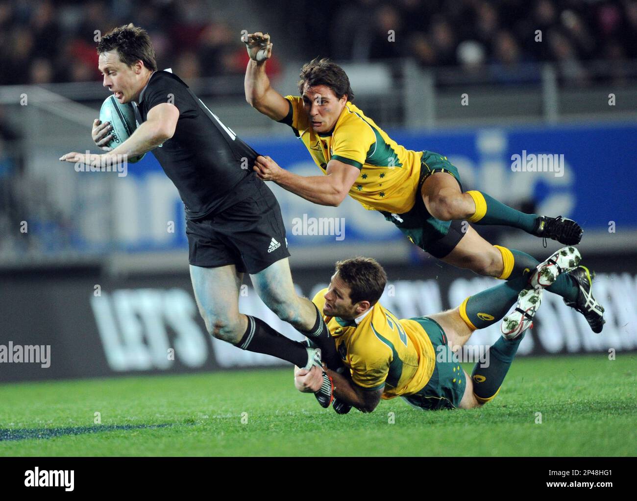 New Zealand’s Ben Smith is tackled by Australia’s Bernard Foley, and Nick Phipps, up, during the International test Bledisloe Cup rugby match at Eden Park in Auckland, New Zealand, Saturday, Aug. 23 2014. (AP Photo/SNPA, Ross Setford) NEW ZEALAND OUT Stockfoto
