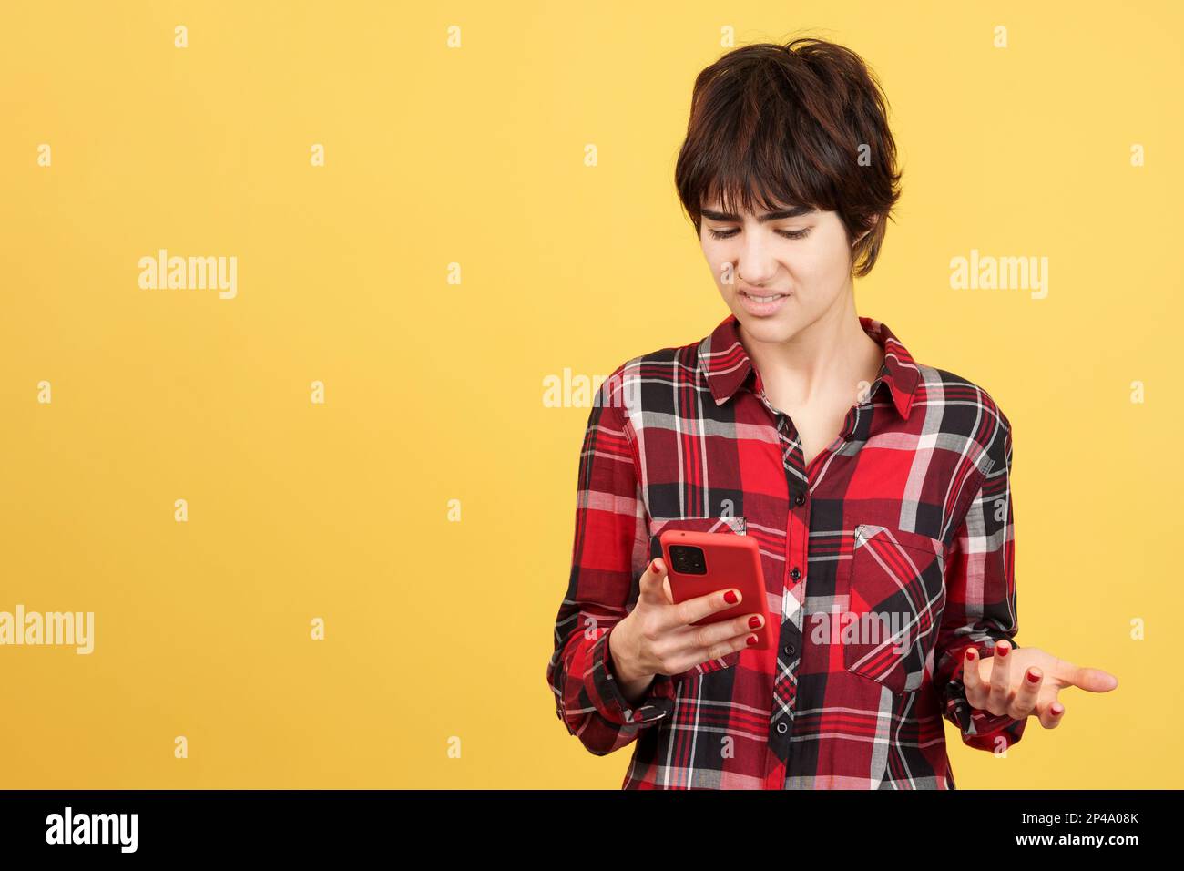 Wütender androgynoser Mensch, der ein Handy benutzt Stockfoto