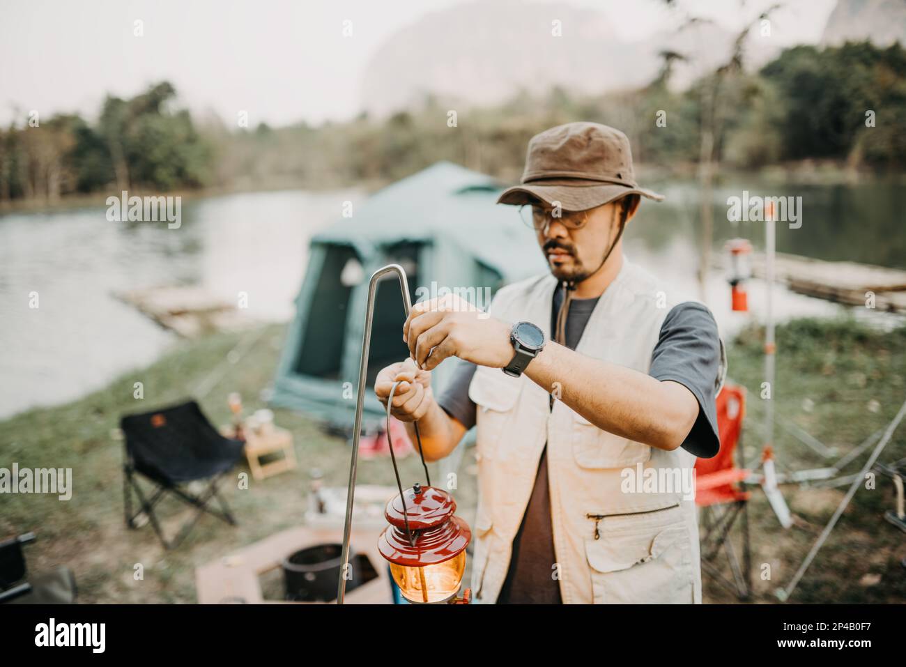 Asiatischer junger Mann, der Laternen zum Campen aufstellt Stockfoto