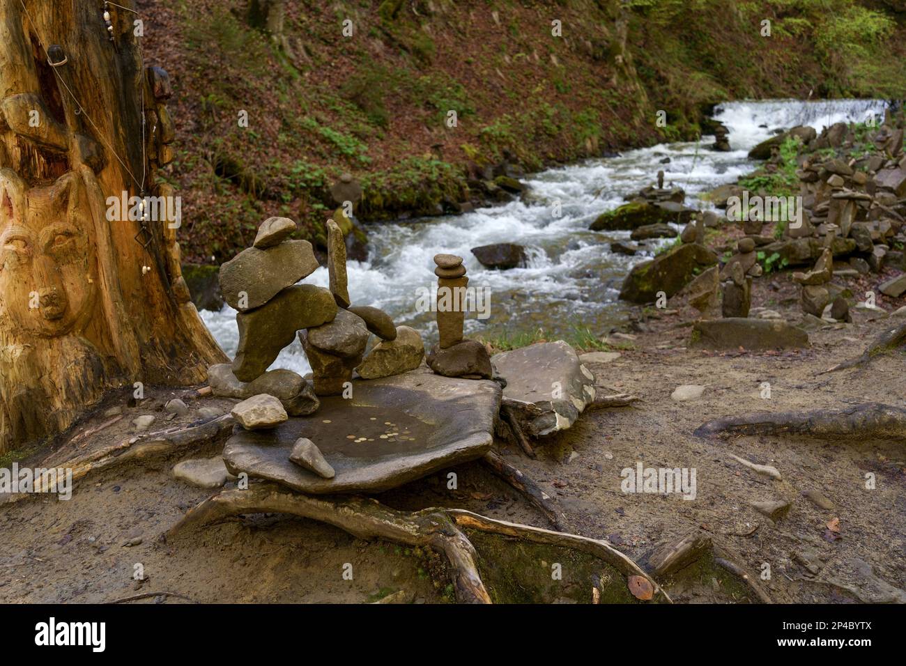 Heidnische Steine in der Nähe von Wasserströmen im Bergwald. Shipot-Wasserfall in den Karpaten. Ukraine. Stockfoto