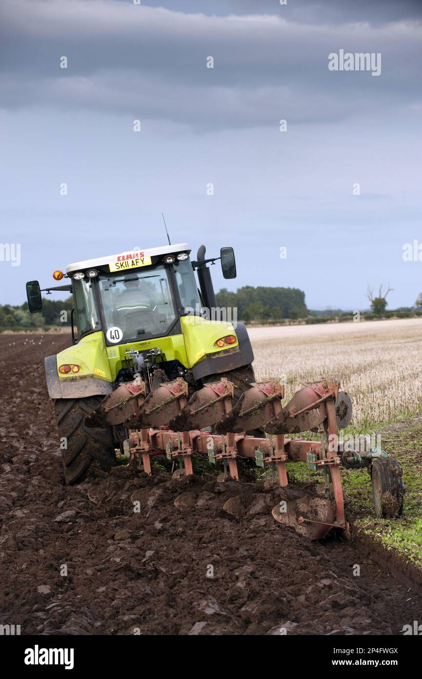 Axion-Traktor Claas 640 mit Umkehrpflug aus fünf Furchen, Pflügen im Stoppelfeld, Schottland, Großbritannien Stockfoto