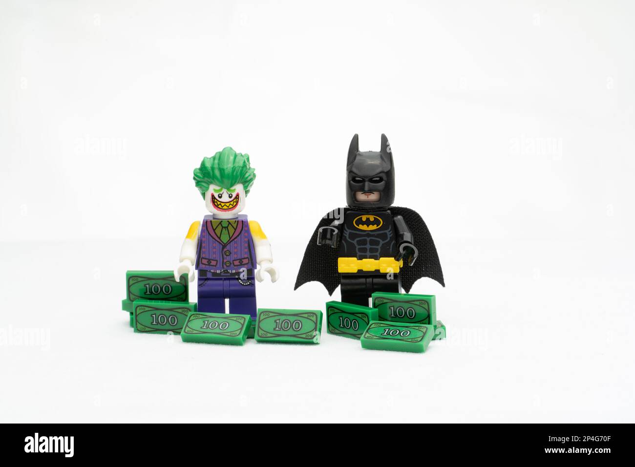 Zwei LEGO-Figuren mit Batman und Joker auf Dollarscheinen isoliert auf weißem Hintergrund Stockfoto