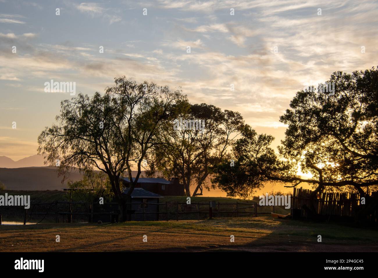 Sonnenaufgang über einem kleinen Bauernhaus auf dem Land Stockfoto