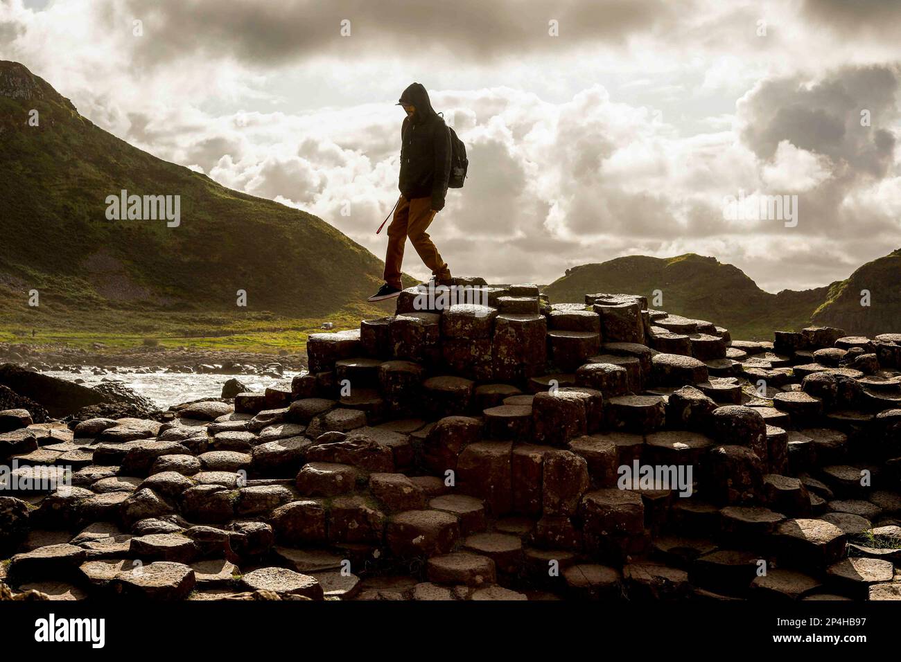 Der Mensch wandert zwischen einzigartigen sechseckigen Felsen in Irland Stockfoto
