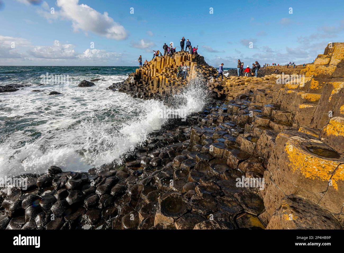 Wellen stürzen am Giant's Causeway ab Stockfoto