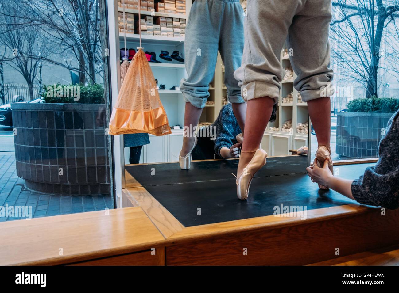 Ein Mädchen, das für Ballettschuhe angepasst wird Stockfoto