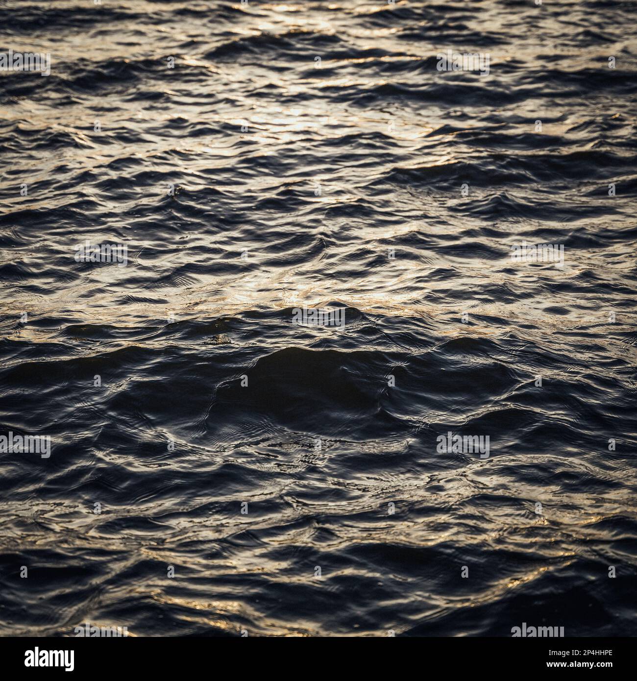 Nahaufnahme der Wasseroberfläche mit Wellen und Wellen und dem Sonnenuntergang Stockfoto