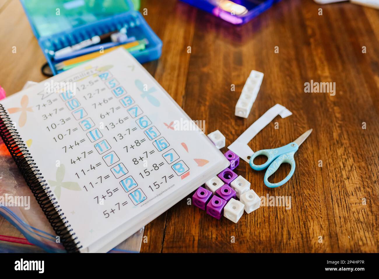 Mathematik-Notizbuch auf Holztisch mit Schere und Schulbedarf Stockfoto