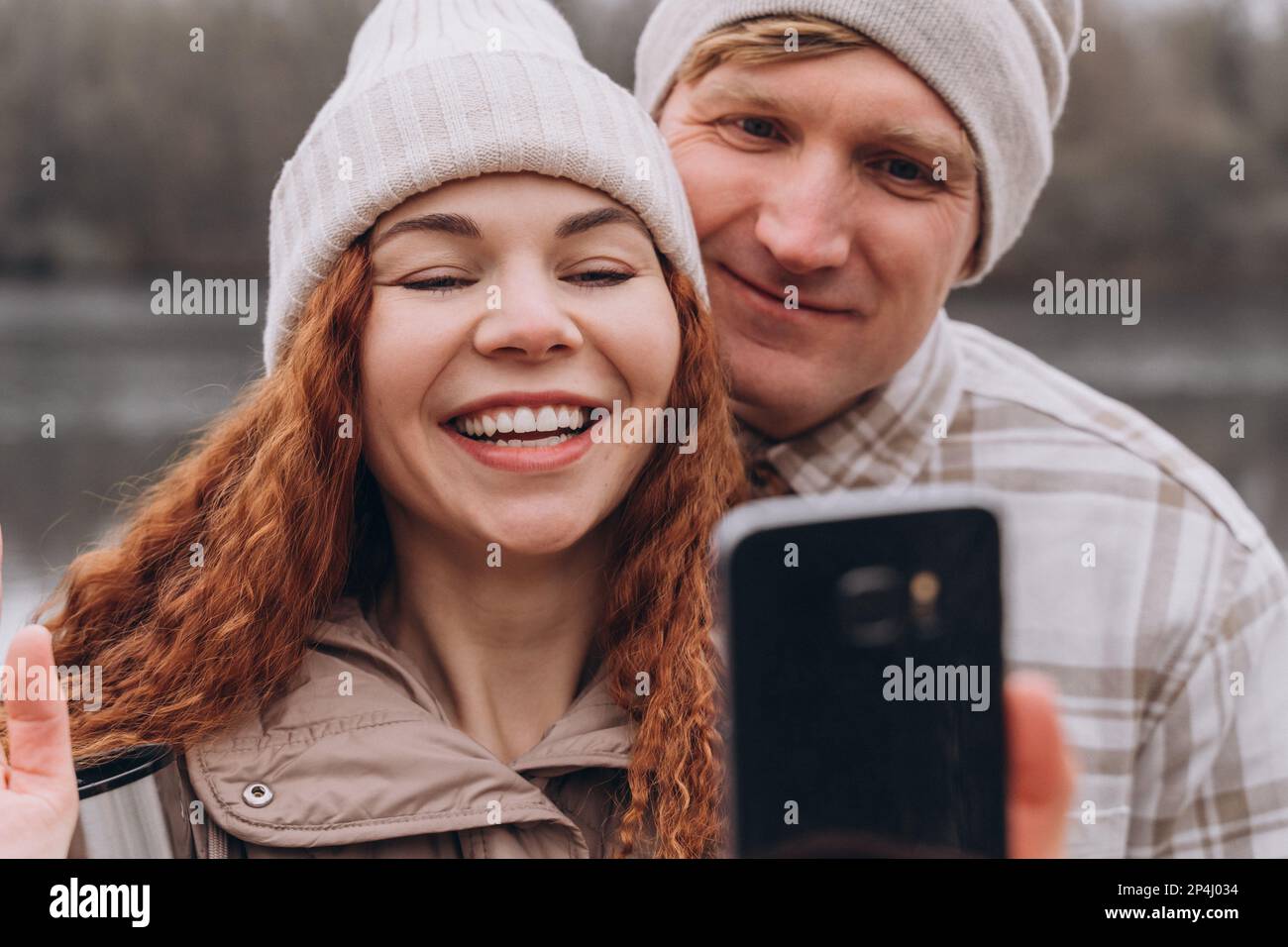 30-35 Paar, das beim Gehen Selfie oder Videoanruf macht Stockfoto