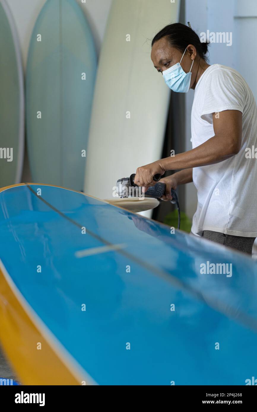 Mann repariert Surfbrett, Hände nah, Surfboard Werkstatt in Bal Stockfoto