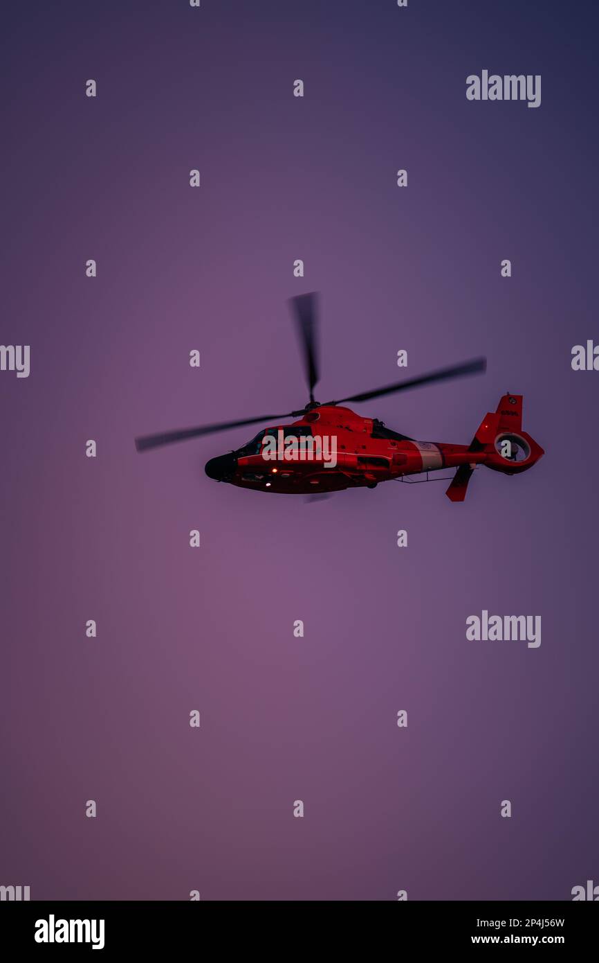 Roter Hubschrauber, der am Himmel fliegt Stockfoto