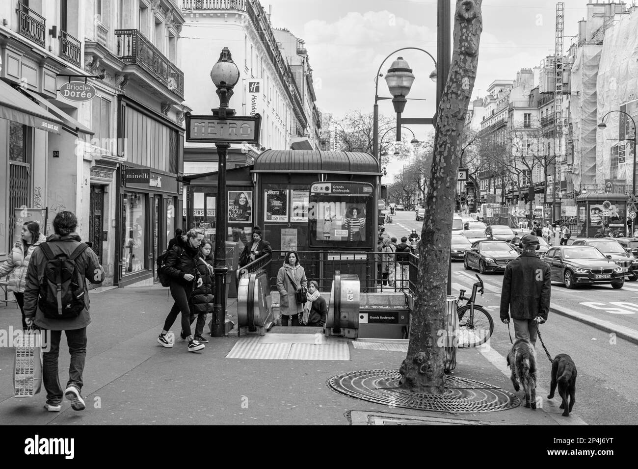 Menschen gehen zu Fuß zum und vom Eingang der Metrostation Grand Boulevard am Boulevard Poissonniere, 2. Arrondissement Paris. Stockfoto