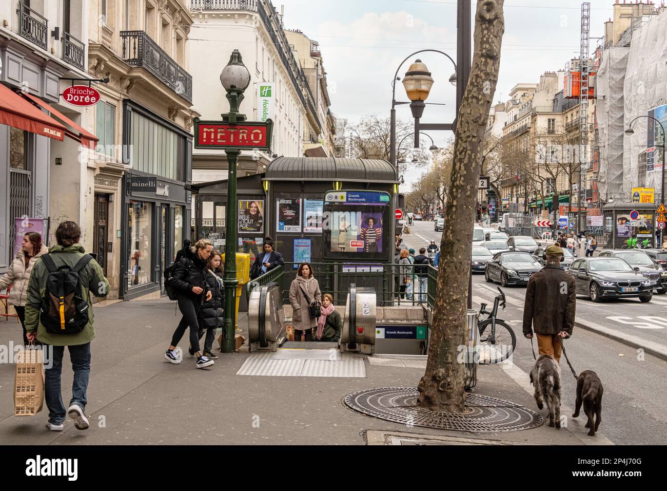 Menschen gehen zu Fuß zum und vom Eingang der Metrostation Grand Boulevard am Boulevard Poissonniere, 2. Arrondissement Paris. Stockfoto