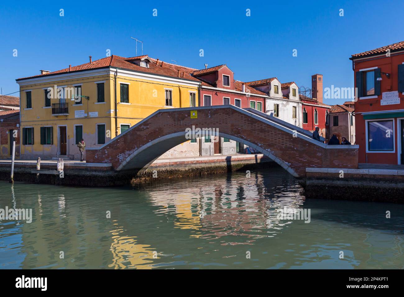 Blick auf Canale di San Donato und Ponte San Martino mit bunten Gebäuden und Brücke auf der Insel Murano, Venedig, Italien im Februar Stockfoto