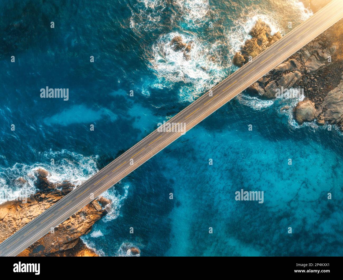 Luftaufnahme der Brücke, Meer mit Wellen und Steinen bei Sonnenuntergang Stockfoto
