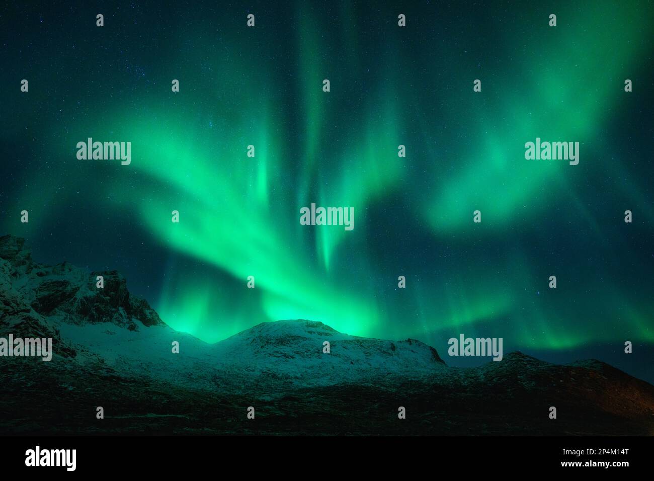 Nordlichter über den schneebedeckten Bergen bei Nacht in Norwegen Stockfoto
