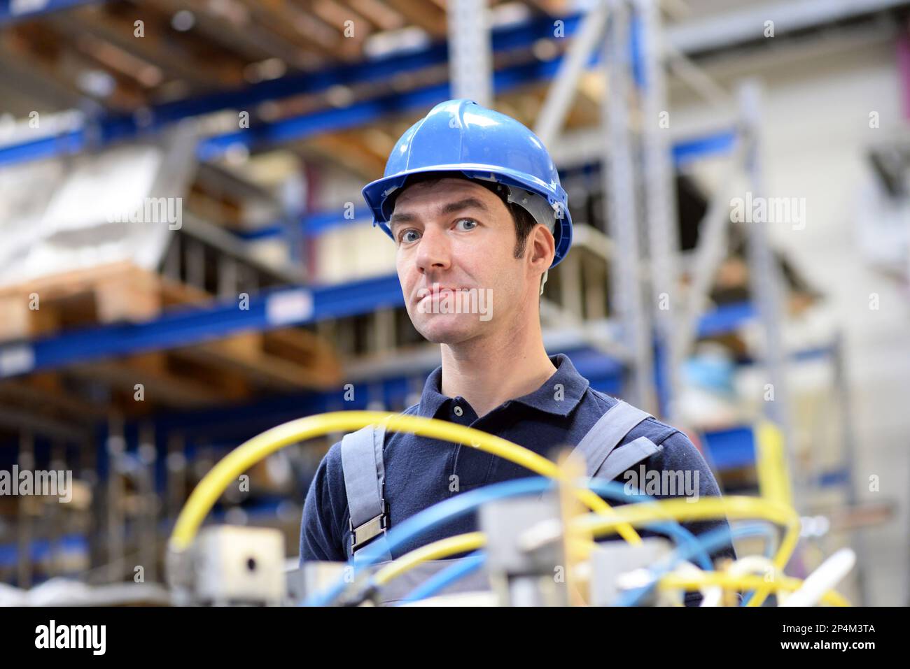 Portrait von erfolgreichen Arbeiter in einem Industrieunternehmen, in Arbeitskleidung am Arbeitsplatz - Nahaufnahme Stockfoto