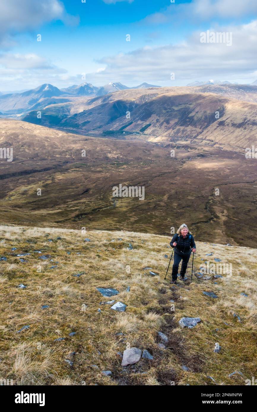 Ein Wanderer auf dem steilen Moor-Pfad den schottischen Munro-Berg von Moruisg hinauf Stockfoto
