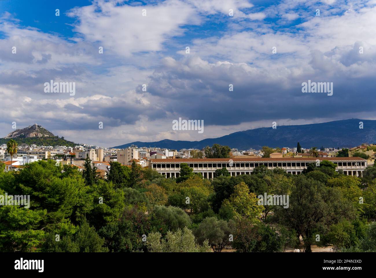 Die Stoa von Attalos, umgeben von grünen Hügeln unter dem bewölkten Himmel in Griechenland Stockfoto