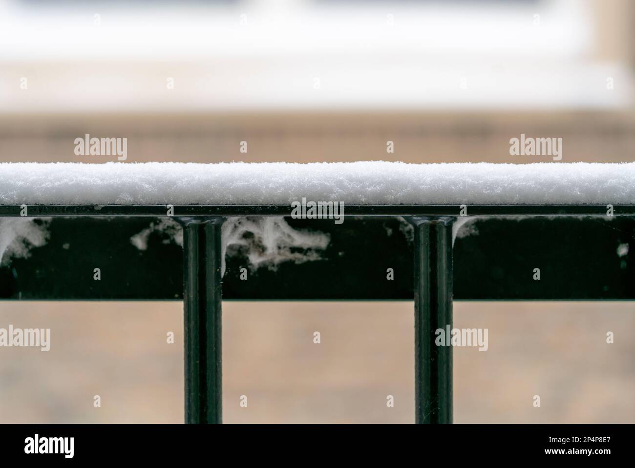 Grüner, eiserner Zaun mit einer Schneeschicht bedeckt, ein frostiger verschneiter holländischer Wintertag draußen mit Platz für Kopien. Stockfoto