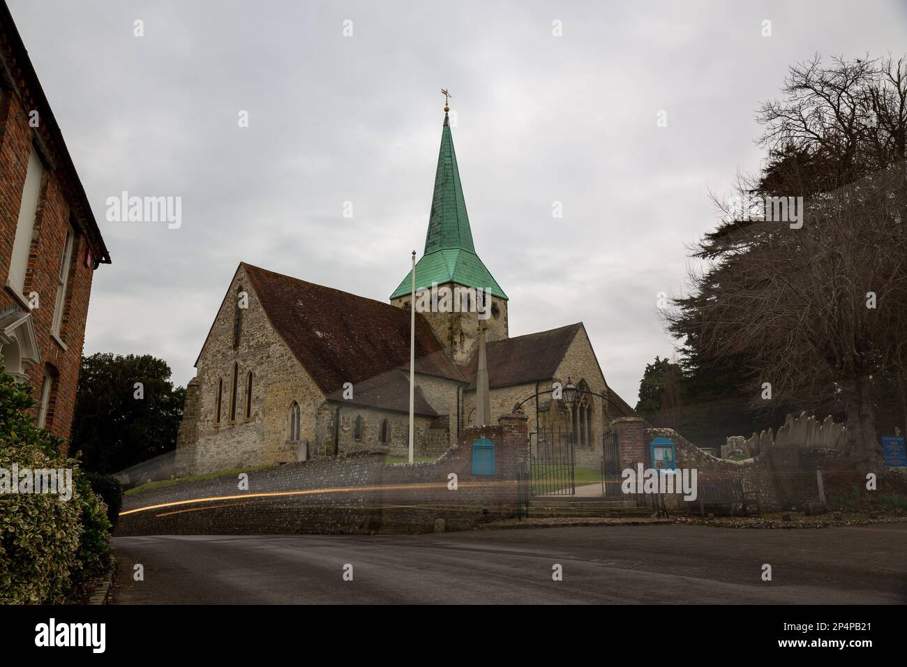 Kirche St. Mary und St. Gabriel in South Harting. Bewegungsunschärfe eines sich schnell bewegenden Fahrzeugs durch das Dorf. Zeigt die Gefahren von Geschwindigkeitsübertretungen. Stockfoto