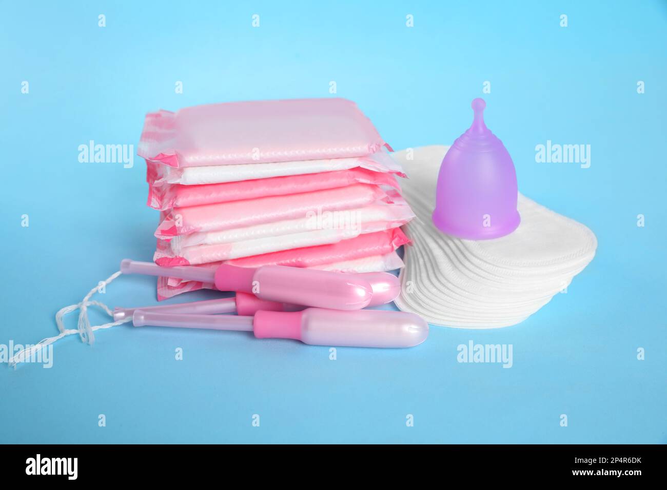 Menstruationseinlagen und andere Hygieneprodukte auf hellblauem Hintergrund Stockfoto