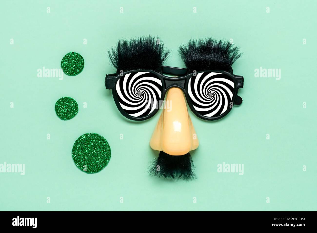 Lustiges Gesicht - gefälschte Brille, Nase und Schnurrbart, Kalenderdatum 01. April auf grünem Hintergrund Happy Narren Day Konzept 1. April Party Holiday Greetind c Stockfoto